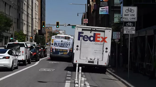 A truck and a bus block a bike lane.