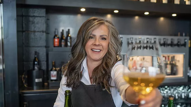 Female cidermaker holding a glass of cider.