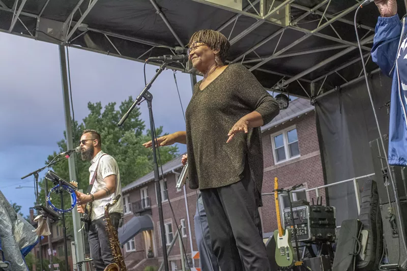 Image: soul singer singing into microphone on stage