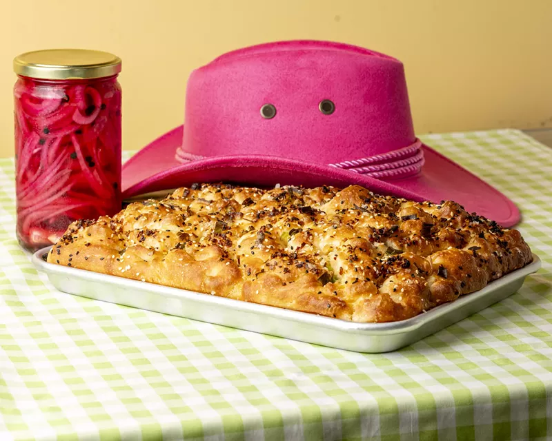 Image: foccacia on a pan in front of a pink cowboy hat