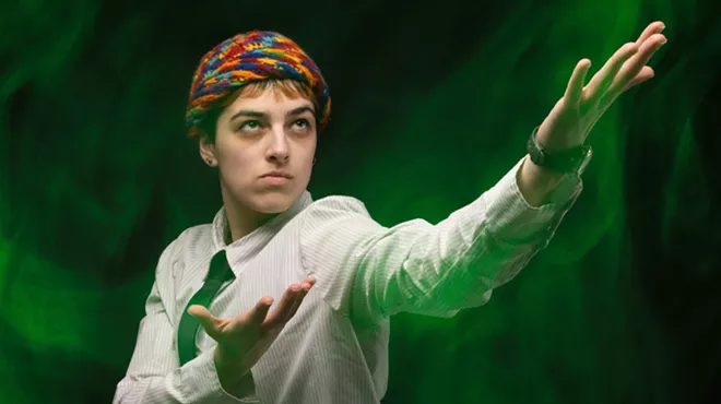 A person poses with green smoke around them.