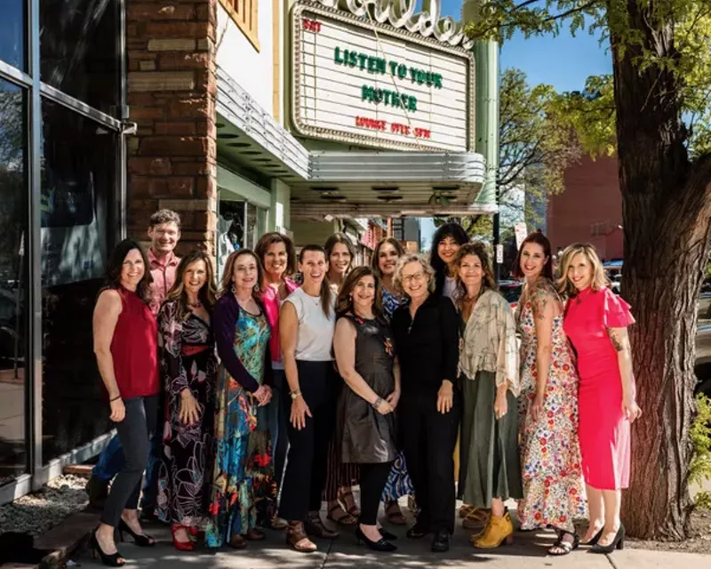 Image: Women stand in front of a theater.