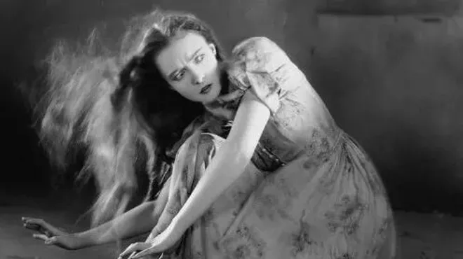 woman in prairie clothes caught in wind crouched on the ground