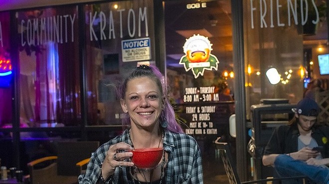 woman outside karma house with cup of kava