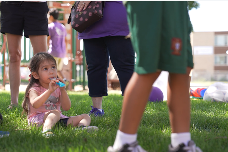 Image: A kid looks up and eats a treat.
