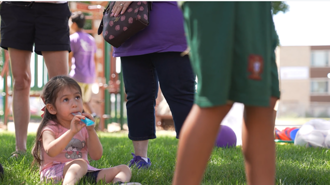 A kid looks up and eats a treat.