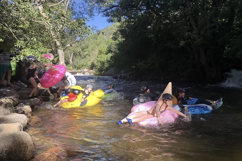 Image: Several people with colorful tubes entering Boulder Creek