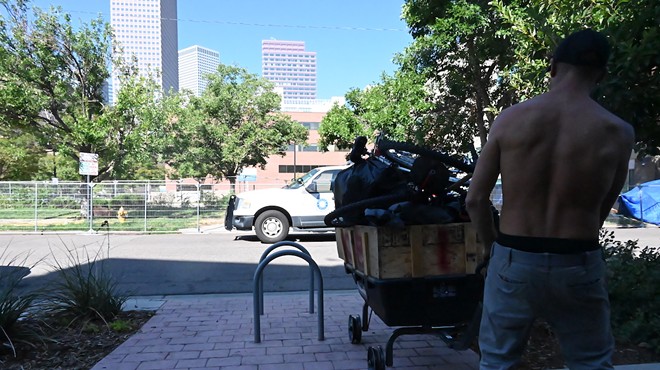 A homeless resident moves their things during a sweep.