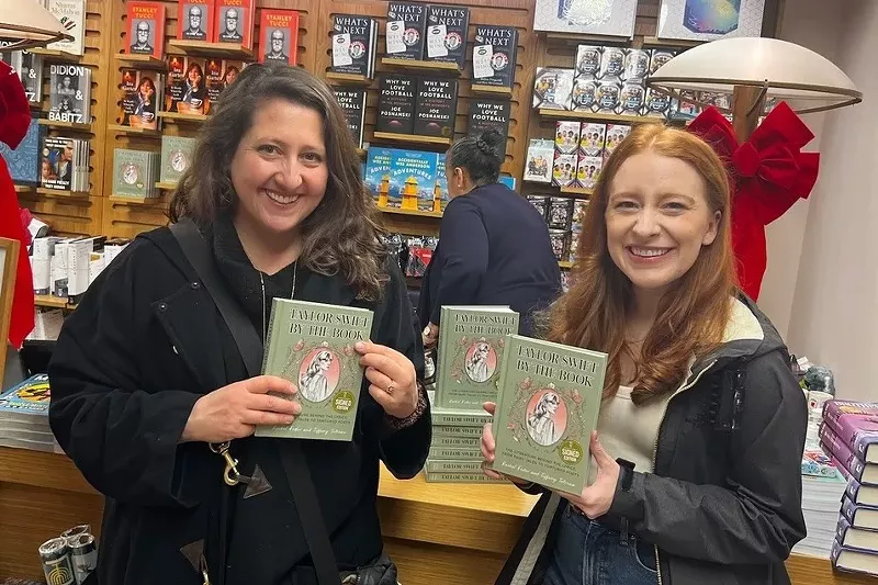 Image: two women hold up books