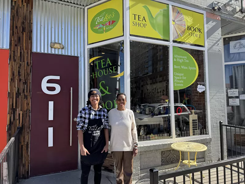 Image: two people standing outside a tea shop