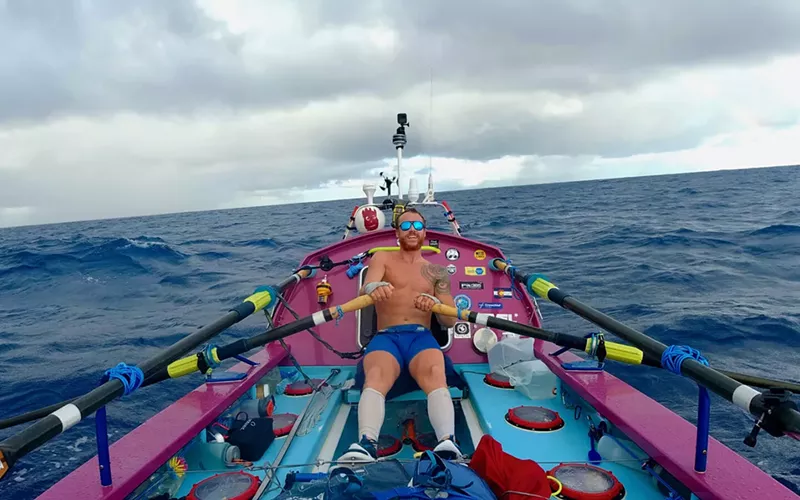 Image: man in boat rowing on ocean