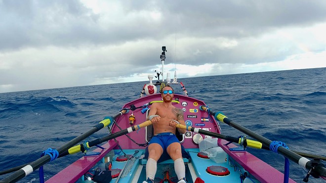 man in boat rowing on ocean