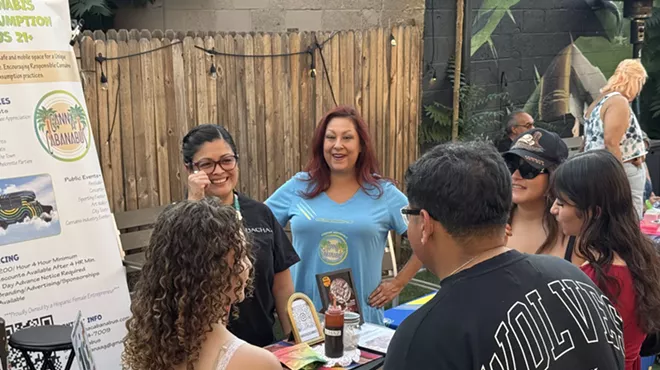 People gather around table in backyard
