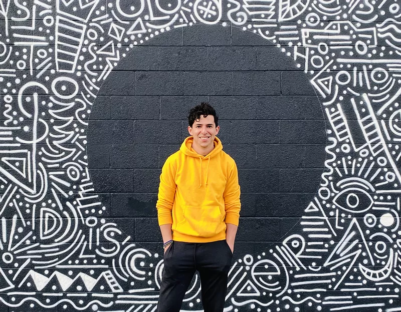 Image: Carlos (Charlo) Garcia Walterbach in front of one of his murals.