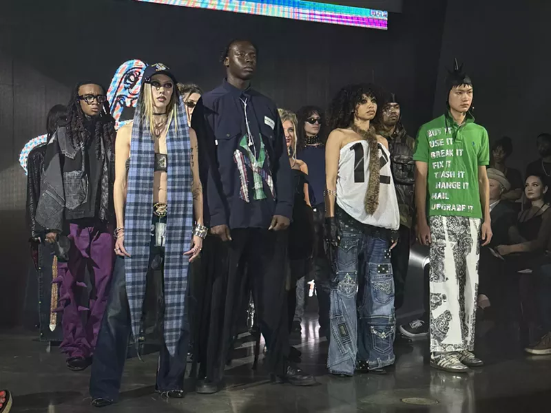 Image: Models stand next to each other in a dark room