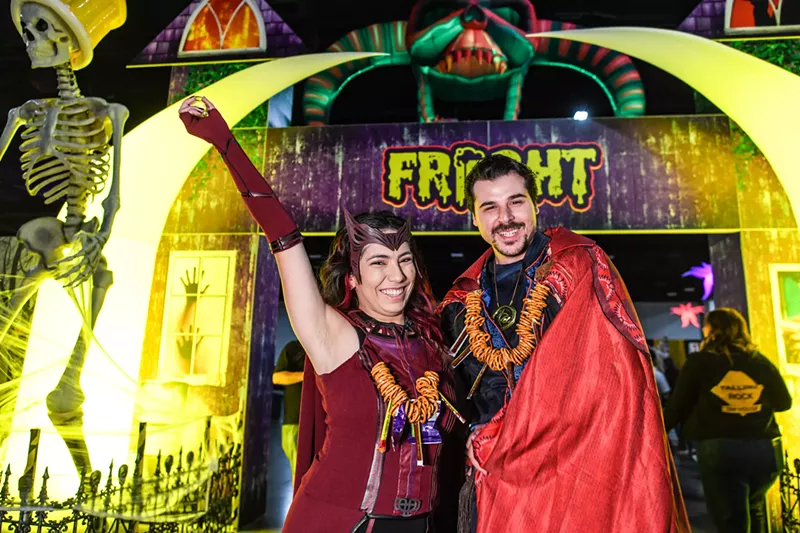 Image: two people wearing costumes and pretzel necklaces