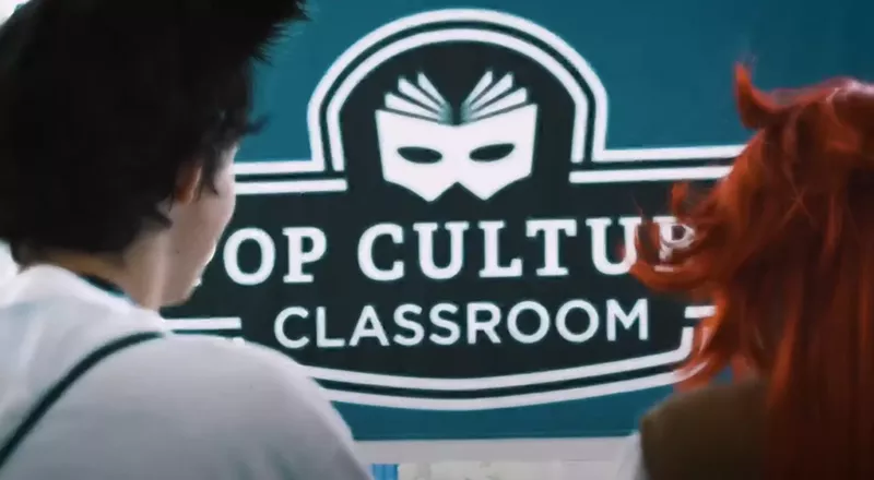 Image: pop culture classroom sign with back of people's heads.
