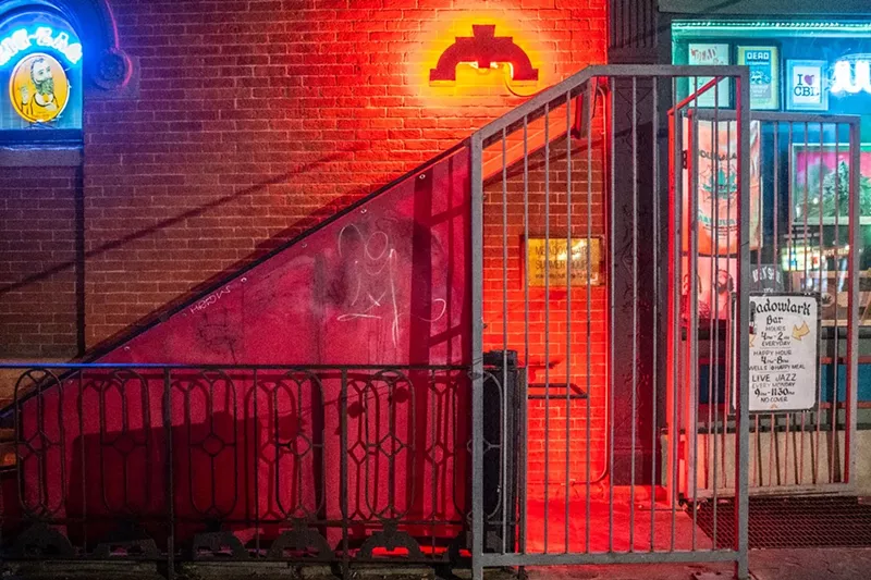 Image: entrance to a basement bar with red light