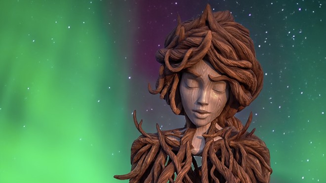 A twisted wood sculpture of a woman backdropped by the northern lights