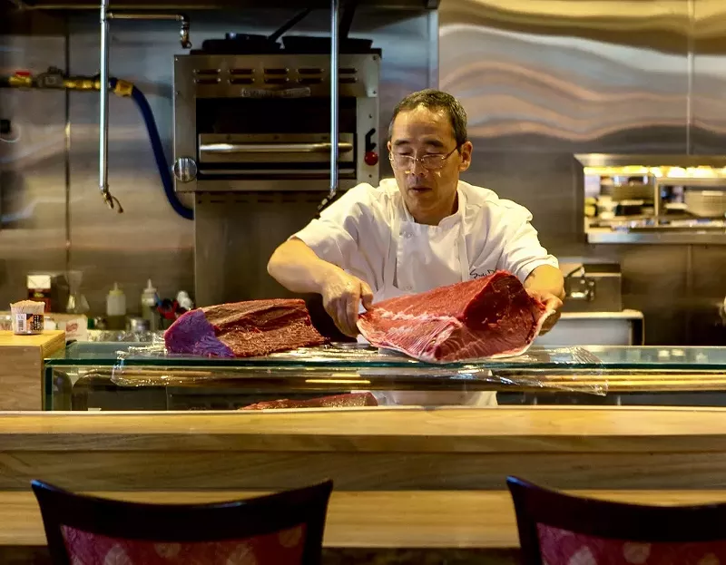 Image: chef holding large piece of fish