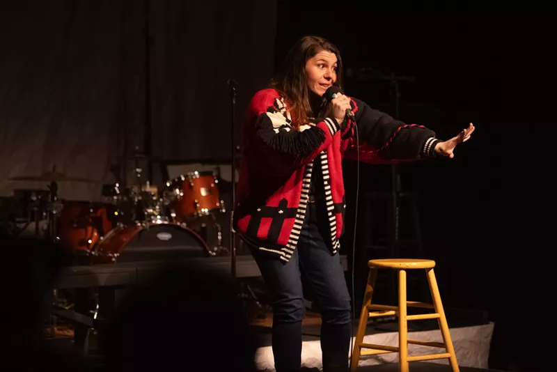 Image: A woman talks into a microphone.