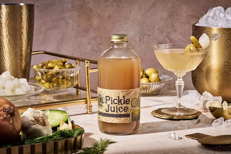 Image: a bottle of pickle juice next to a martini