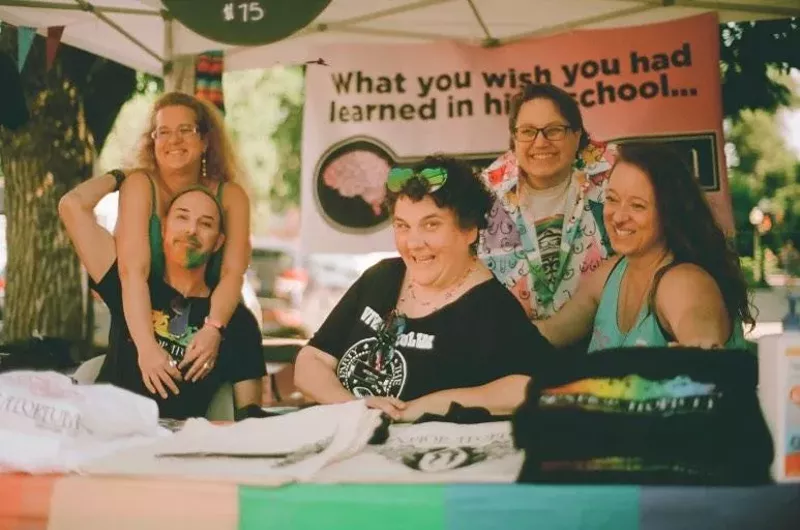 Image: women laughing at a booth