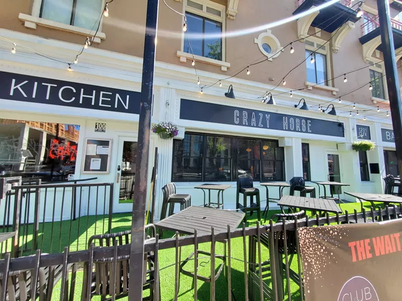 Image: the front of a white building with green turf on the patio