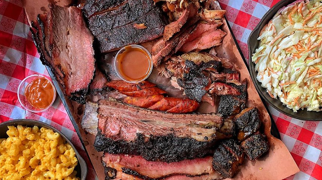 a tray of smoked meats and sides