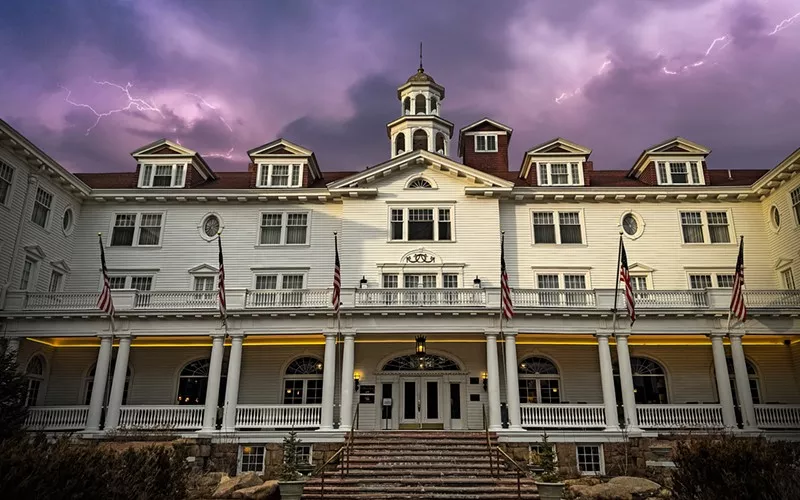 Image: The exterior of the Stanley Hotel backdropped by a stormy sky