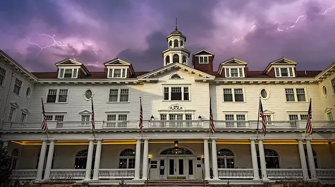 The exterior of the Stanley Hotel backdropped by a stormy sky