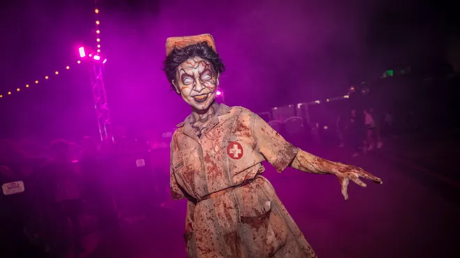 A 13th Floor Haunted House actor dressed in a blood-stained nurse costume