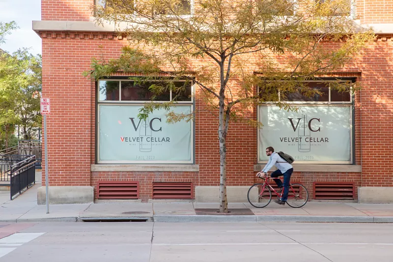 Image: man riding bike in front of a brick building