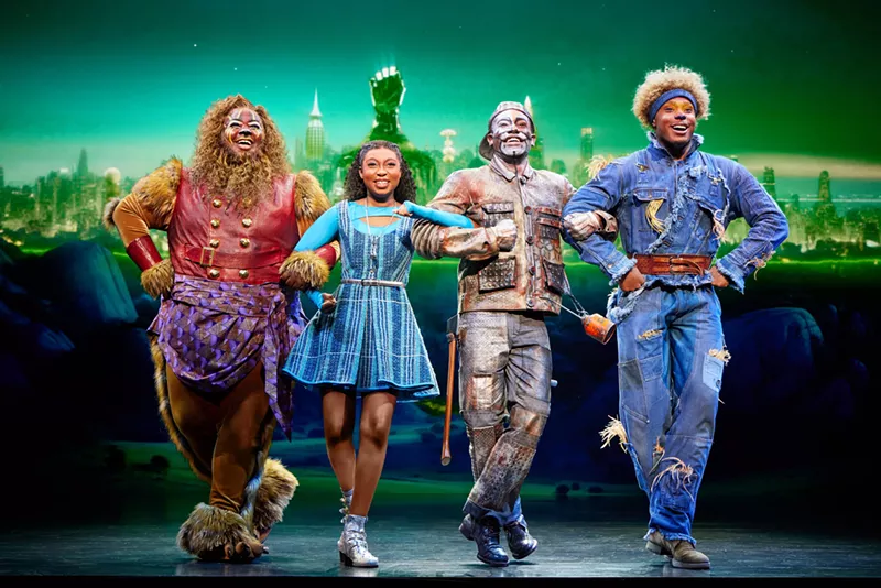 Image: The Lion, Dorothy, Tin Man and Scarecrow walk together.
