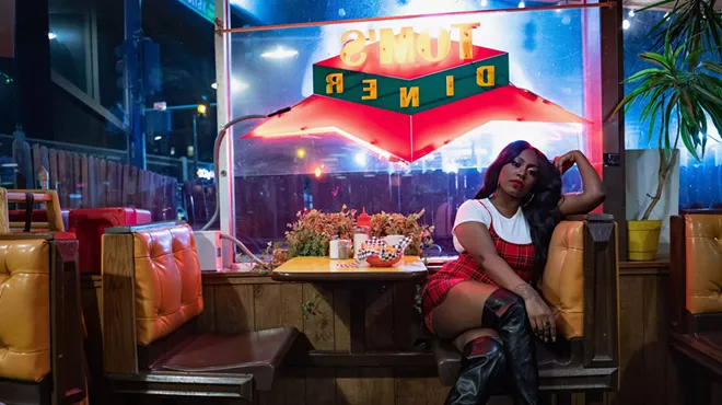 woman poses at a diner booth