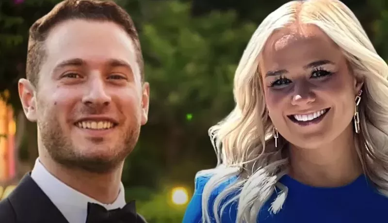 Image: white guy in suit and blonde woman in blue shirt