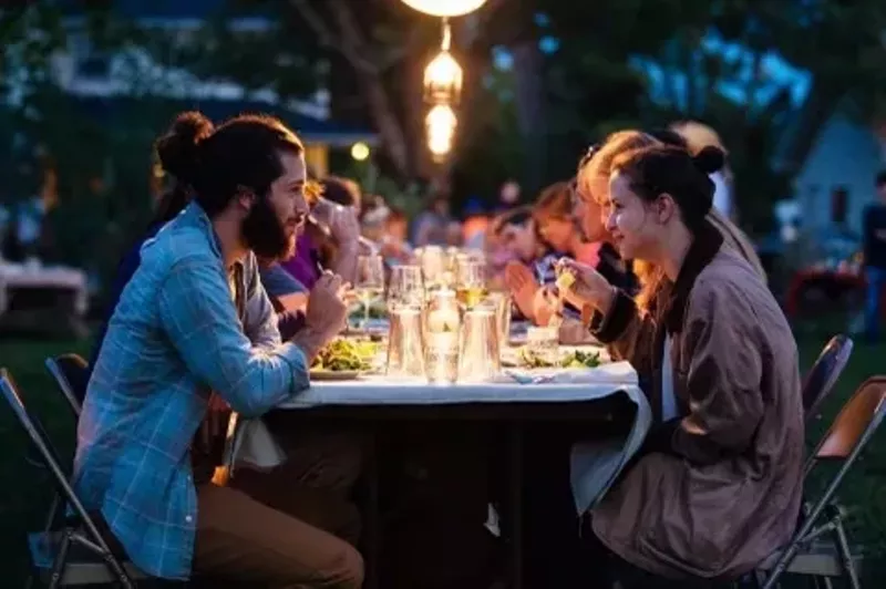 Image: people sitting at a dining table outside