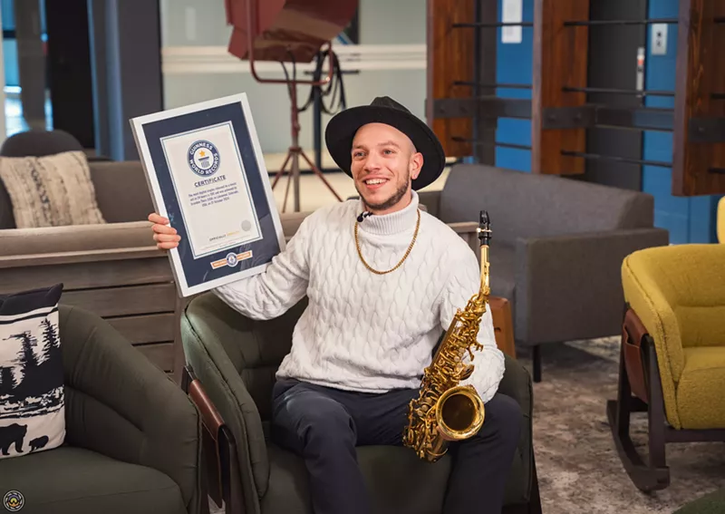 Image: man with certificate and saxophone
