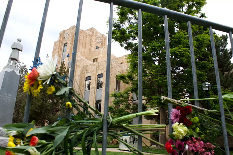 Image: Flowers line a fence in front of the historic Boulder County Courthouse, the site of Sunday's hate crime attack.