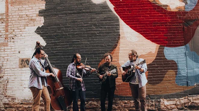bluegrass band performing in front of a mural