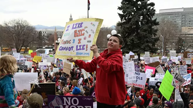 A kid raises a sign.