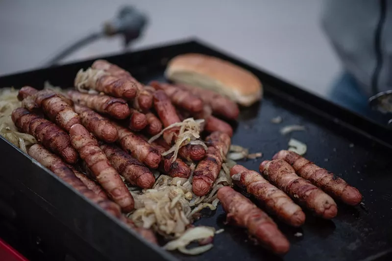Image: Hot dogs onions and buns on the grill