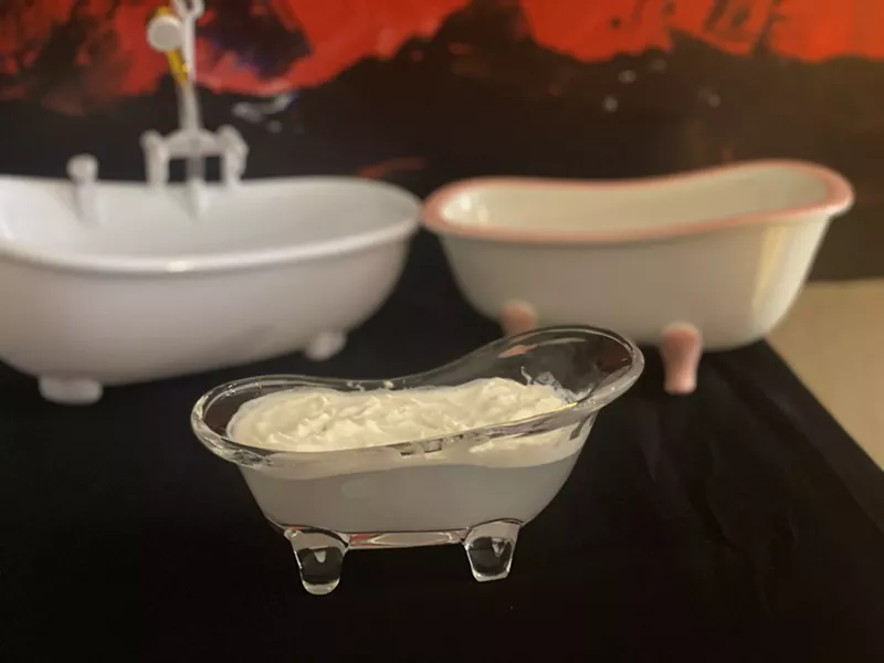 Image: a white cocktail in a bathtub-shaped glass