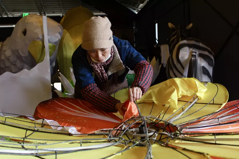 Image: A woman paints a giant cloth flower