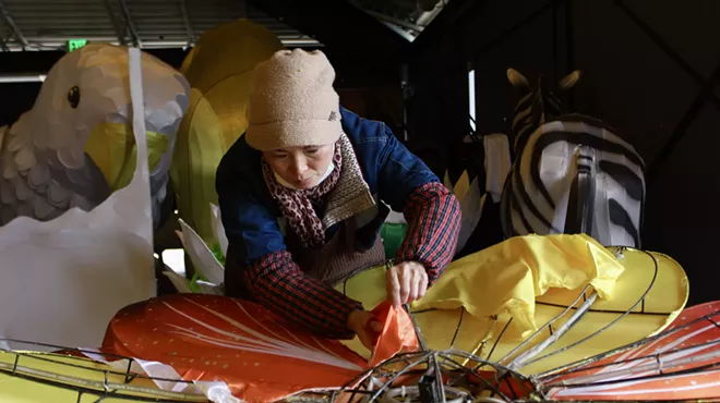 A woman paints a giant cloth flower