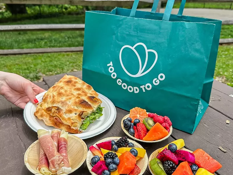 Image: various food on plates in front of a green bag