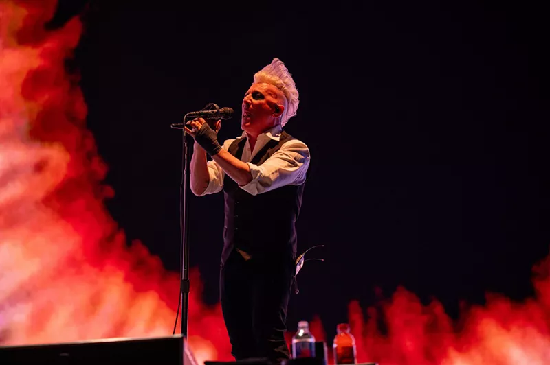 Image: blonde man sings into microphone