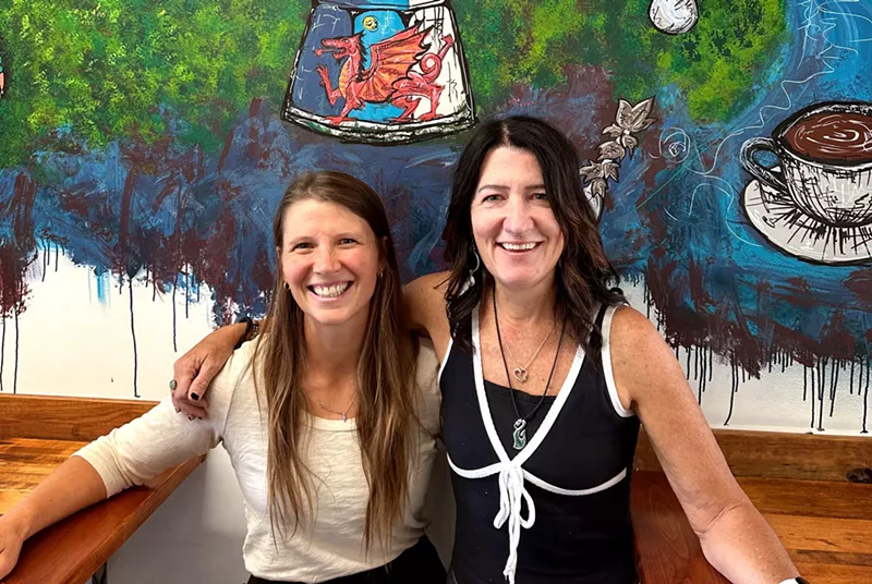Image: two women posting in front of a mural