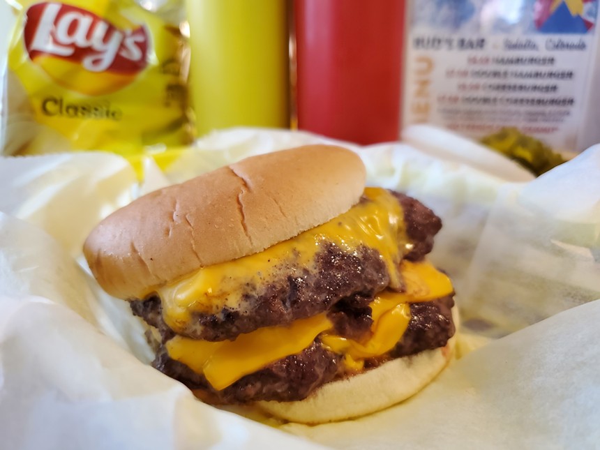 a double cheeseburger in front of a bag of Lay's chips