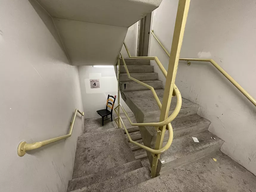 A broken chair in a stair landing at Columbine Towers. - CATIE CHESHIRE